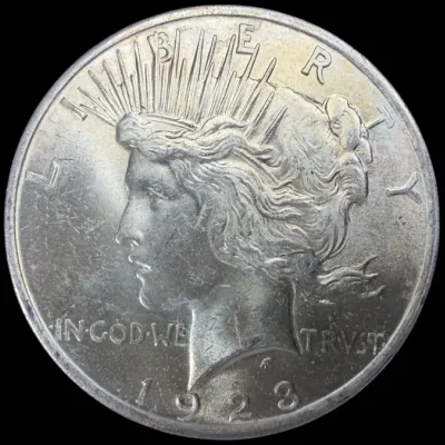 Sale Photo Thumbnail #38: 1923 United States Peace Silver Dollar featuring Liberty in profile with a radiate crown on the obverse.