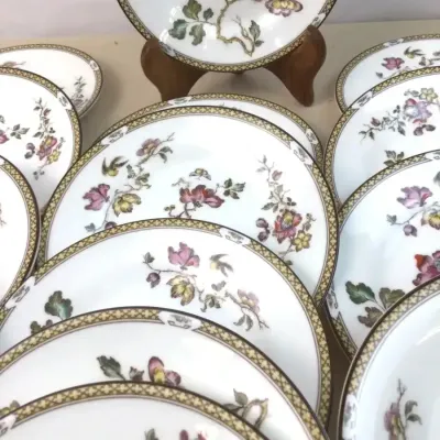 Sale Photo Thumbnail #114: Set of vintage fine porcelain dinnerware featuring an Asian-inspired floral botanical motif and geometric patterned borders.