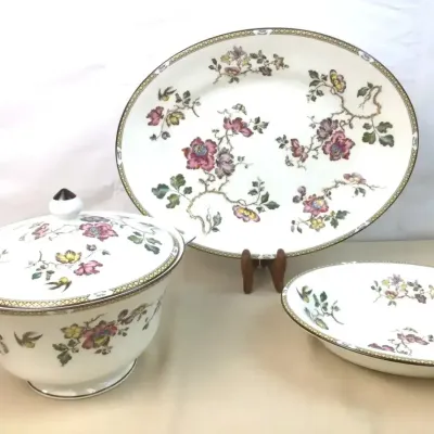 Sale Photo Thumbnail #116: Three-piece vintage china set, including a covered tureen, large oval platter, and serving bowl, decorated with a pink and yellow floral chintz-style pattern and geometric borders.