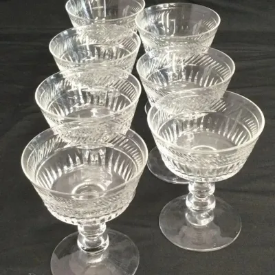 Sale Photo Thumbnail #96: Set of seven vintage cut crystal sherbet or champagne coupe glasses featuring a ribbed stem and decorative etched details.