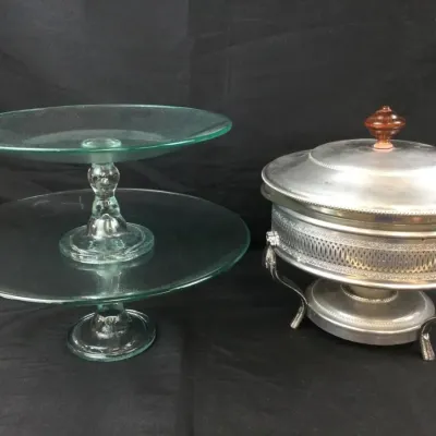Sale Photo Thumbnail #81: Pair of green glass pedestal cake stands alongside a silver-plated chafing dish with a covered lid and amber glass finial.