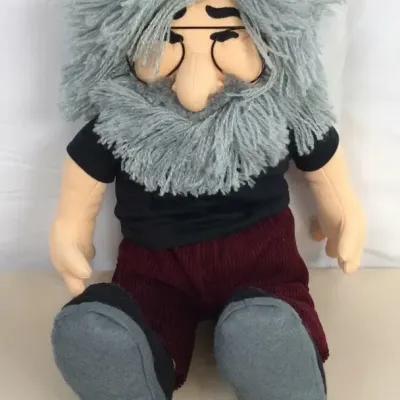Sale Photo Thumbnail #41: Plush Jerry Garcia doll featuring grey yarn hair and beard, glasses, a black t-shirt, and corduroy pants.