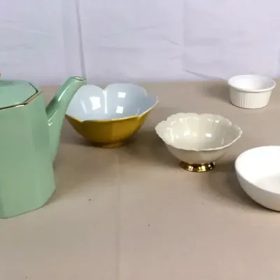 Sale Photo Thumbnail #78: Collection of ceramic tableware including a sage green teapot with gold accents, small bowls, and a white dish featuring a figurine of a bunny.