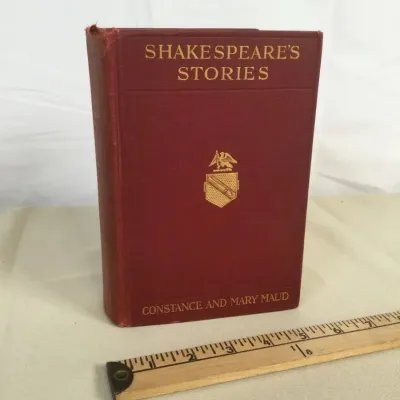 Sale Photo Thumbnail #5: Vintage hardbound copy of 'Shakespeare's Stories' by Constance and Mary Maud, featuring a red cloth cover with gold-embossed lettering and crest details.