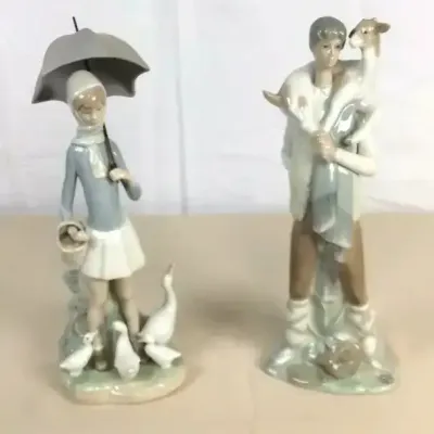 Sale Photo Thumbnail #55: Pair of Lladro porcelain figurines, featuring a girl with an umbrella surrounded by ducks and a shepherd carrying a lamb.