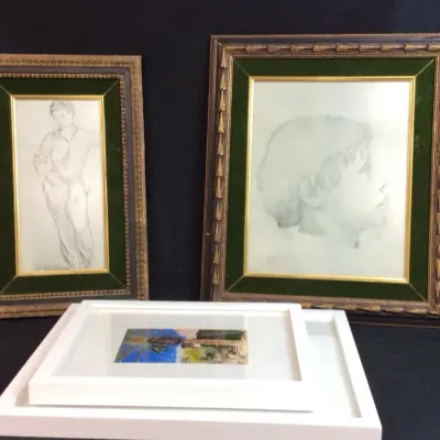 Sale Photo Thumbnail #69: Collection of framed artwork, including two vintage charcoal portrait sketches in ornate dark wood and green velvet matting, alongside framed landscape prints.