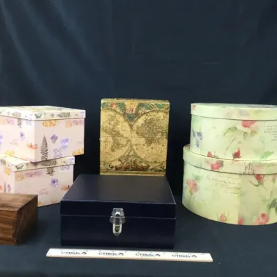 Sale Photo Thumbnail #28: Collection of decorative storage boxes, including a dark blue latching case, floral oval hat boxes, map-printed containers, and a small wooden box.