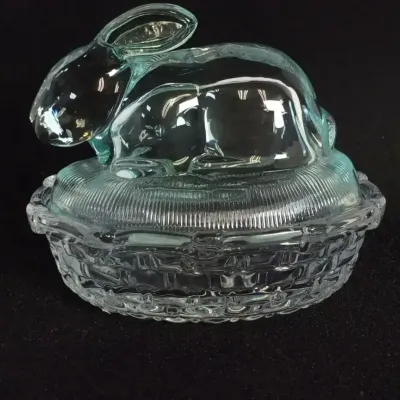 Sale Photo Thumbnail #13: Vintage clear pressed glass rabbit on a basket covered dish, featuring a textured nest lid and woven-pattern base.