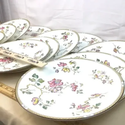 Sale Photo Thumbnail #117: Set of vintage fine china plates with hand-painted floral branch motifs and gilded patterned rims.