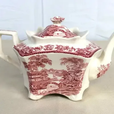 Sale Photo Thumbnail #71: Vintage pink transferware ceramic teapot featuring a scalloped rim, footed base, and detailed landscape scenes.