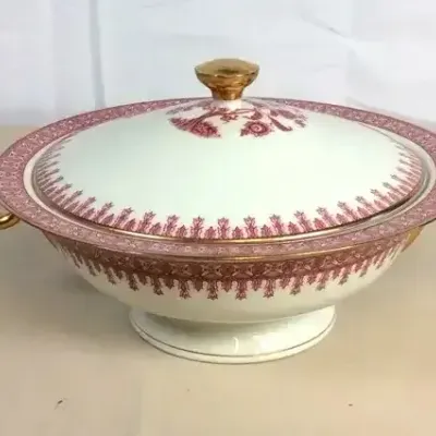Sale Photo Thumbnail #107: Vintage porcelain covered tureen featuring an ornate pink-and-maroon patterned border with gilded handles and finial.