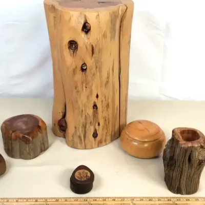 Sale Photo Thumbnail #32: Collection of handcrafted rustic wood decor pieces, including a tall polished log pedestal, small boxes, and a carved hollow log vase.