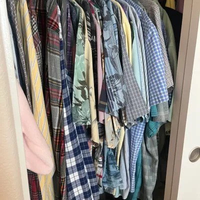 Sale Photo Thumbnail #213: Closet packed with men's button-up shirts, featuring a variety of plaid, striped, and Hawaiian tropical patterns.