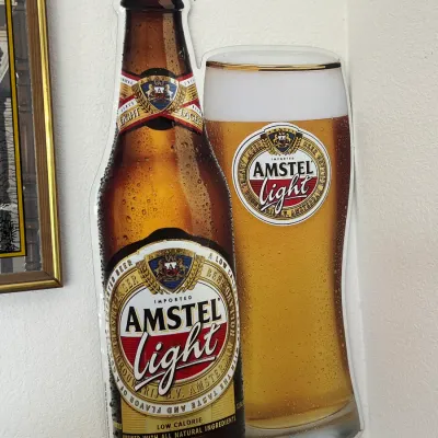Sale Photo Thumbnail #247: Die-cut Amstel Light promotional bar sign depicting a beer bottle and filled pint glass.