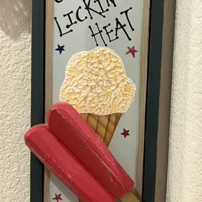 Sale Photo Thumbnail #62: Rustic framed summer sign featuring 3D wooden popsicles and an ice cream cone design with the phrase "Just LICKIN' THE HEAT".