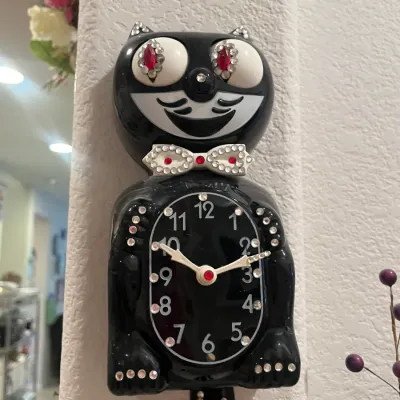 Sale Photo Thumbnail #66: Vintage-style black Kit-Cat Klock embellished with clear and red rhinestones on the eyes, bowtie, paws, clock face, and tail.