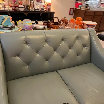 Sale Photo Thumbnail #147: Contemporary light blue leather loveseat featuring a button-tufted diamond pattern backrest and sloped arms.