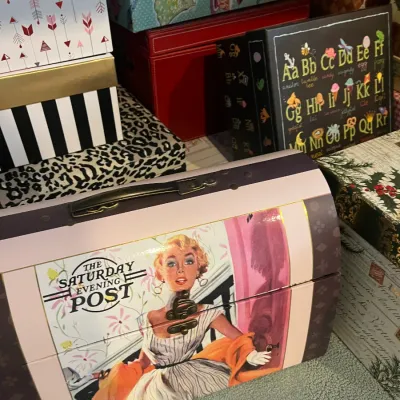 Sale Photo Thumbnail #215: Vintage-style Saturday Evening Post decorative trunk box with metal clasp and handle, displayed alongside various patterned storage boxes.