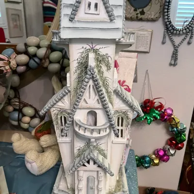 Sale Photo Thumbnail #172: Hand-painted white miniature Victorian castle or birdhouse featuring intricate trim and hand-drawn floral accents.