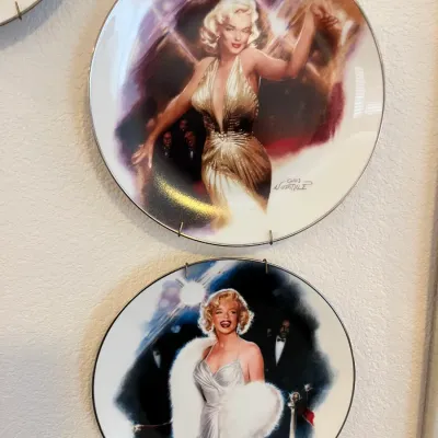 Sale Photo Thumbnail #139: Pair of vintage Marilyn Monroe collector plates by artist Chris Notarile, displayed in wire wall hangers.