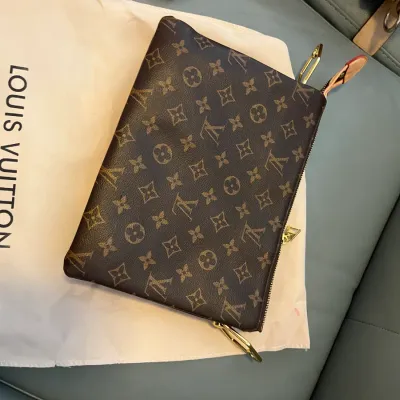 Sale Photo Thumbnail #49: Louis Vuitton monogram canvas clutch bag resting on a branded dust bag.