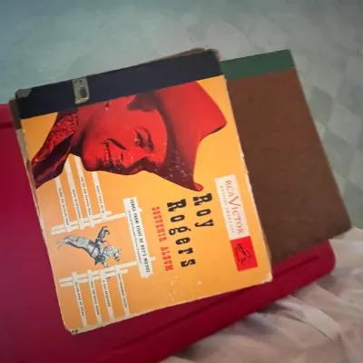 Sale Photo Thumbnail #113: Vintage RCA Victor Roy Rogers Souvenir Album 78 RPM record set resting on top of a red plastic storage container.