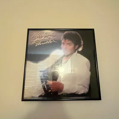 Sale Photo Thumbnail #88: Framed copy of Michael Jackson's 1982 vinyl album Thriller, displayed in a simple black frame.