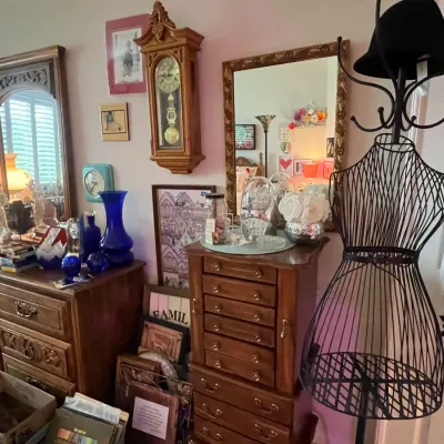 Sale Photo Thumbnail #96: A room featuring a large wooden dresser with mirror, a wooden pendulum wall clock, a standing jewelry armoire, and a wire dress form mannequin.