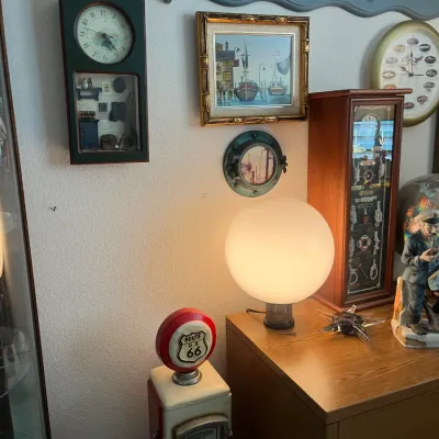 Sale Photo Thumbnail #211: Eclectic collection of nautical decor, including a lighted globe lamp, framed harbor art, wall clocks, and a miniature vintage Route 66 gas pump model.