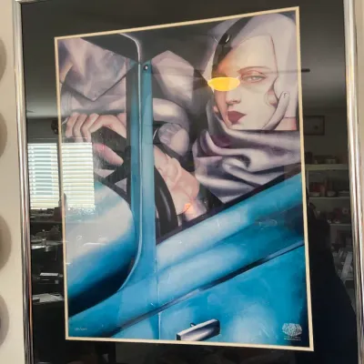 Sale Photo Thumbnail #3: Framed Art Deco style art print featuring Tamara de Lempicka's iconic 'Autoportrait (Tamara in a Green Bugatti)' artwork, presented in a black mat and chrome frame.