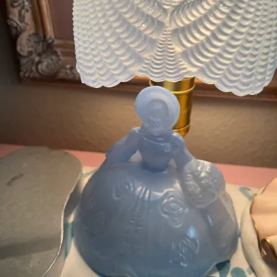 Sale Photo Thumbnail #190: Vintage light blue frosted glass Southern Belle figurine lamp, featuring a textured ruffle-style glass shade.