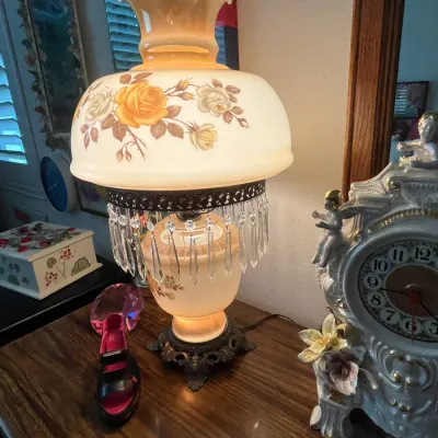 Sale Photo Thumbnail #102: Vintage Fenton-style hurricane lamp featuring hand-painted yellow roses, hanging glass prisms, and an ornate brass base.
