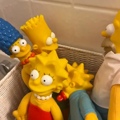 Sale Photo Thumbnail #220: Vintage 1990s The Simpsons plush figures with vinyl heads arranged in a white woven basket.