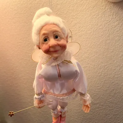 Sale Photo Thumbnail #230: Handcrafted hanging fairy godmother doll featuring a detailed resin face, white hair, pink satin outfit, sheer wings, and a tiny wand.