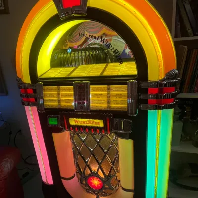Sale Photo Thumbnail #81: Vintage Wurlitzer Model 1015-style illuminated jukebox with colorful neon tubing, chrome accents, and visible record carousel.