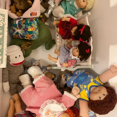 Sale Photo Thumbnail #179: Collection of vintage plush toys and dolls, including Cabbage Patch Kids, sock monkeys, and small doll furniture stored together in a bin.