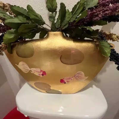 Sale Photo Thumbnail #125: Hand-painted metallic gold ceramic boat vase with goldfish motif, filled with faux floral stems.
