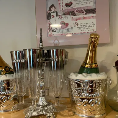 Sale Photo Thumbnail #32: Set of Millennium 2000 commemorative champagne bucket ice containers and matching silver-toned champagne flutes displayed on a shelf.