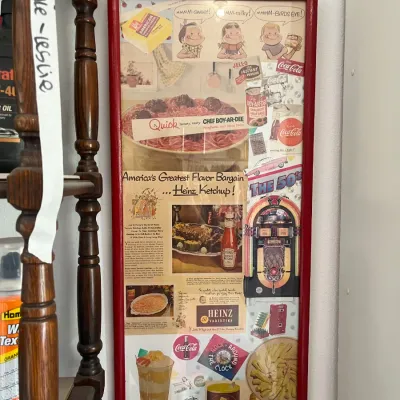 Sale Photo Thumbnail #245: Framed 1950s-themed advertising collage featuring vintage magazine clippings of Heinz Ketchup, Chef Boy-Ar-Dee, Coca-Cola, and jukebox imagery set in a red wooden frame.
