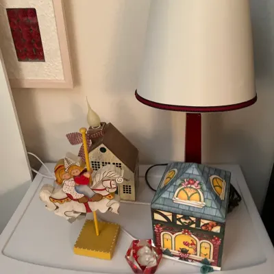 Sale Photo Thumbnail #224: Collection of decorative household items including a small table lamp with a maroon base, a wooden carousel horse figurine, and a house-shaped music box.