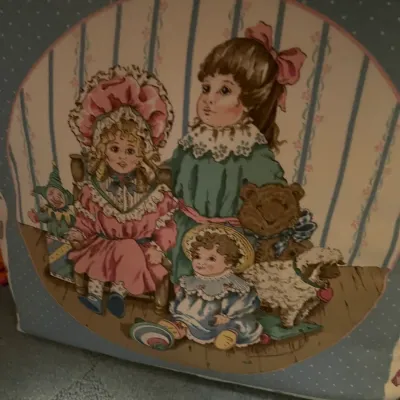 Sale Photo Thumbnail #137: Vintage printed fabric throw pillow featuring a Victorian-style illustration of young girls, dolls, and stuffed animals.