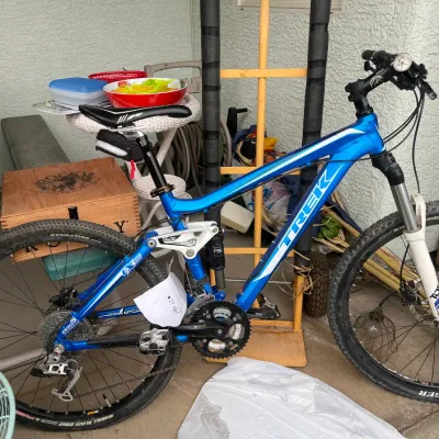 Sale Photo Thumbnail #146: Trek EX6 full-suspension mountain bike in metallic blue, featuring front and rear shocks and Bontrager tires.