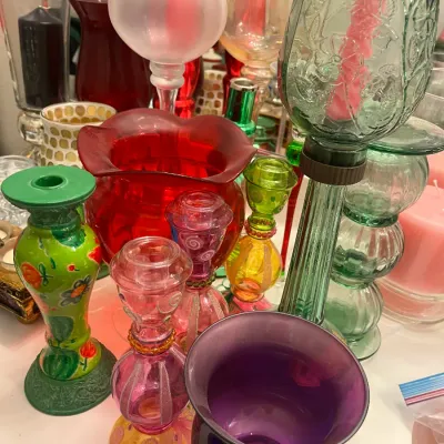 Sale Photo Thumbnail #218: Collection of colorful vintage glass candle holders and vases, including painted, frosted, and embossed pieces in various shades of red, green, purple, and pink.