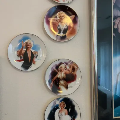 Sale Photo Thumbnail #45: Set of five vintage Marilyn Monroe collector plates displayed in wire wall hangers, featuring various iconic portraits.