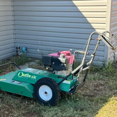 Sale Photo Thumbnail #18: Billy Goat Outback walk-behind brush cutter, featuring a green steel deck & Honda engine.