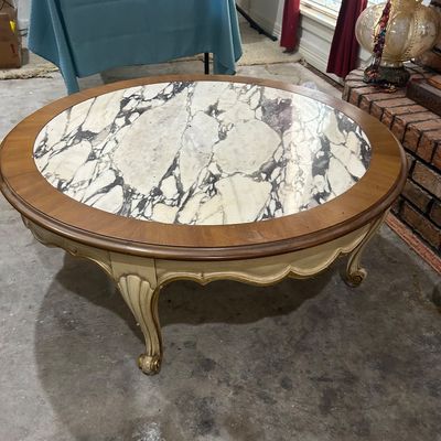 Vintage French Provincial style round coffee table featuring an inset marble top, wood trim, and a painted distressed base with cabriole...