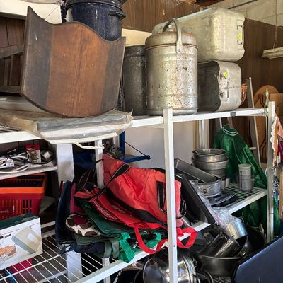 Sale Photo Thumbnail #88: White wire shelving unit filled with vintage cookware, metal containers, reusable tote bags, and a wooden cradle.