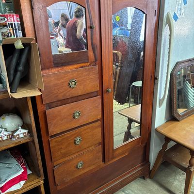 Sale Photo Thumbnail #46: Vintage wooden armoire with mirrored cabinet doors, a column of four stacked drawers, and ornate brass hardware.