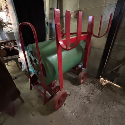 Sale Photo Thumbnail #106: Vintage heavy-duty industrial welder mounted on a red wheeled cart with cable racks, showing age-appropriate wear and patina.