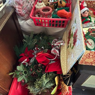 Sale Photo Thumbnail #41: Collection of holiday decor items, including artificial greenery, red ribbons, a basket of novelty soap dispensers, and decorative boxes.